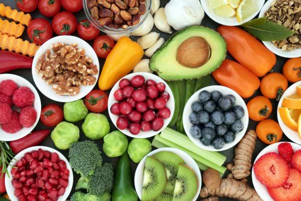 une table remplie d'aliments bons pour la sant&eacute; : noix, tomates, poivrons, brocolas...
