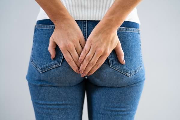 une femme met ses deux mains devant les fesses