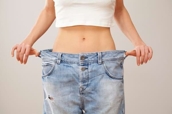 une personne avec un jean trop grand par rapport &agrave; son tour de taille
