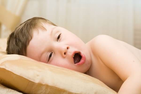 un enfant allong&eacute; qui baille