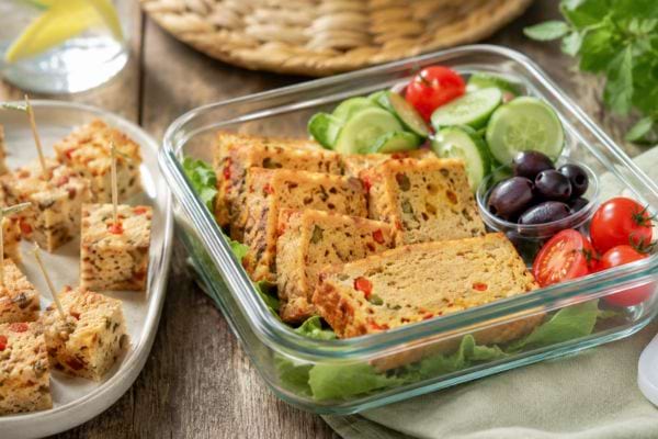 Tranches de flan au thon préparées à l’avance dans une lunchbox avec légumes frais.