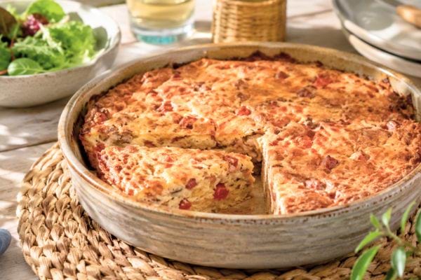 Flan provençal au thon doré dans un plat, servi avec une salade verte.