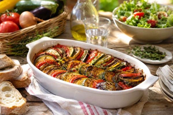Tian de légumes maison servi avec du pain et une salade pour un repas d’été simple et économique.
