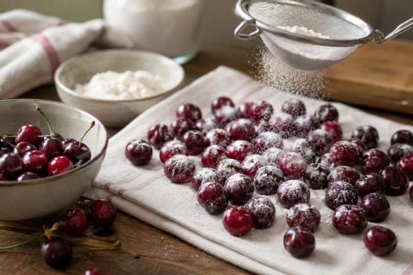Cerises fraîches séchées sur un torchon et saupoudrées de farine.