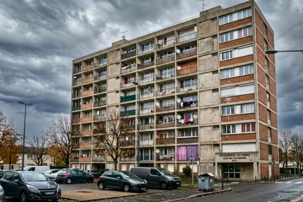 un immeuble de logements sociaux (HLM) en France sous un ciel nuageux