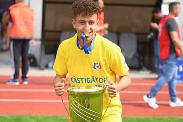 Un jeune footballeur tenant une coupe