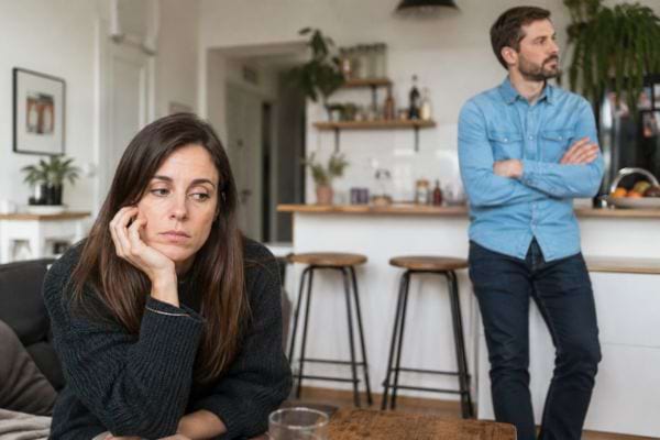 Femme triste mise à distance par un homme dans un appartement