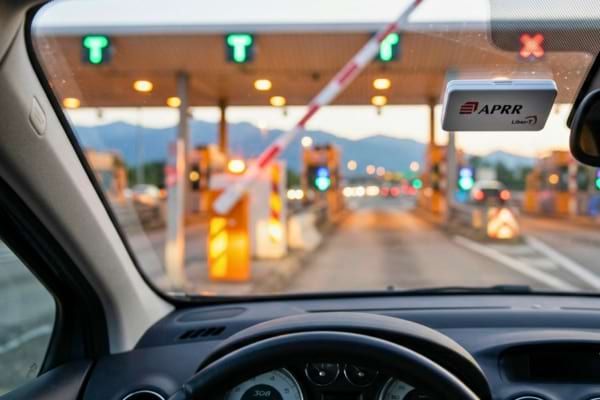 un badge de t&eacute;l&eacute;p&eacute;age blanc fix&eacute; sur le pare-brise int&eacute;rieur d'une voiture