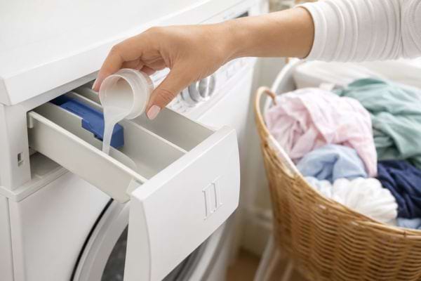 Lessive liquide vers&eacute;e dans le compartiment II du lave-linge pour le lavage principal.