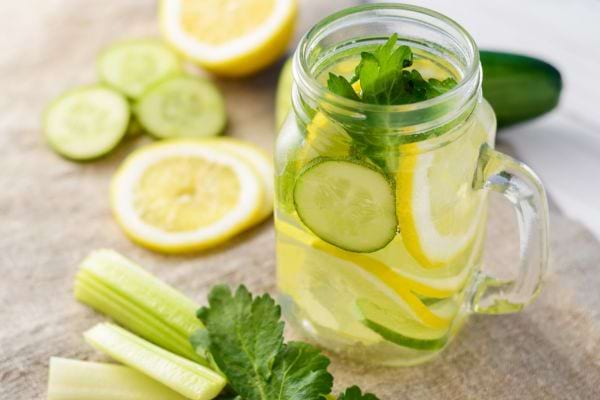 une eau de concombre avec du citron dans un mug transparent