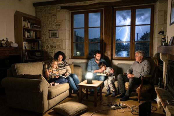 famille sans &eacute;lectricit&eacute; dans le salon de leur maison pendant orage