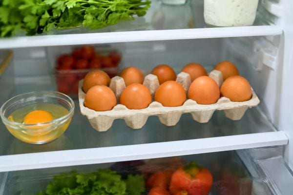 Bo&icirc;te d&rsquo;&oelig;ufs conserv&eacute;e sur une &eacute;tag&egrave;re du r&eacute;frig&eacute;rateur