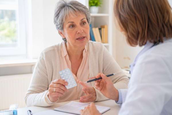 Patiente montrant ses somnifères à une médecin pour discuter des risques de perte de mémoire.
