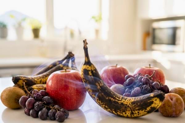 une banane bien m&ucirc;re et une pomme rouge plac&eacute;es c&ocirc;te &agrave; c&ocirc;te