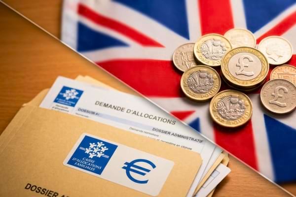 des pièces de monnaie avec le symbole de la livre sterling posées sur un drapeau britannique flouté
