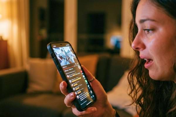 'un smartphone tenu en main affichant une vidéo virale avec de nombreux commentaires