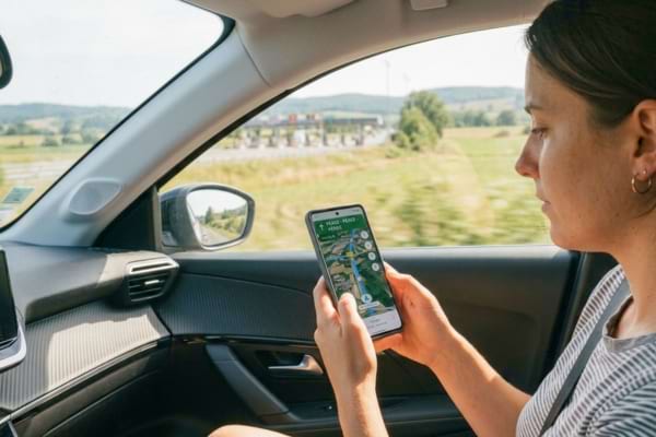 une personne tenant un smartphone affichant une application de carte GPS 