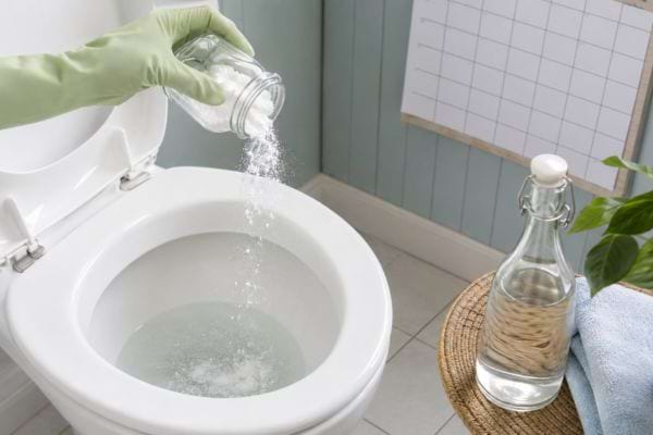 Bicarbonate versé dans la cuvette pour prévenir le retour du tartre.