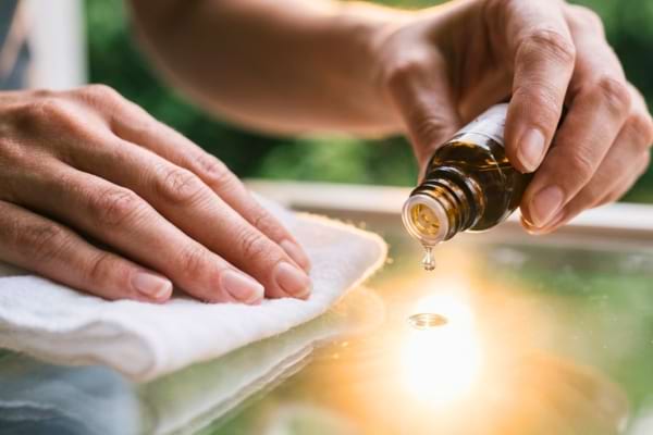 hands holding a soft, dry white cotton cloth, applying a tiny drop of clear glycerin onto a pristine,