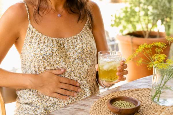 Femme buvant une infusion de fenouil pour soulager le ventre gonflé