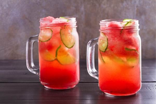 Deux boissons fraîches à la pastèque et au concombre avec des glaçons.