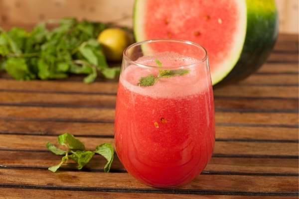 Jus frais de pastèque à la menthe servi dans un verre.