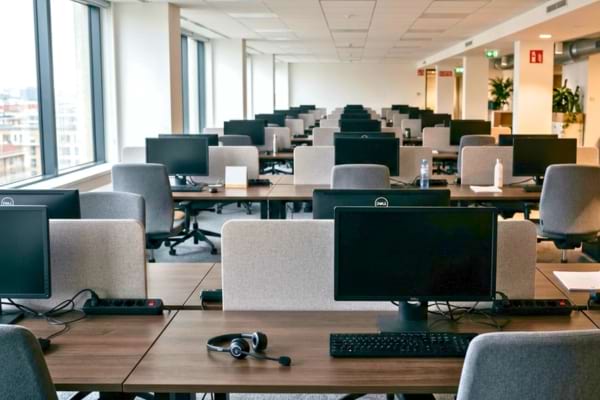 un centre d'appels moderne complètement vide, casques téléphoniques posés sur les bureaux