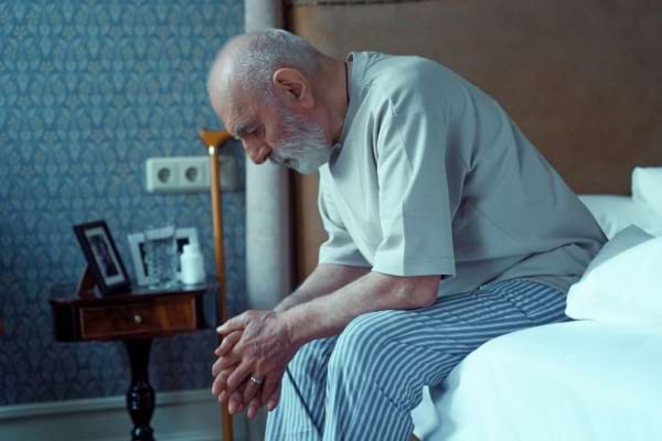 Une personne âgée épuisée sur son lit