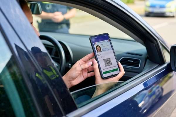 une personne tenant un smartphone moderne affichant une application d'identité numérique sécurisée