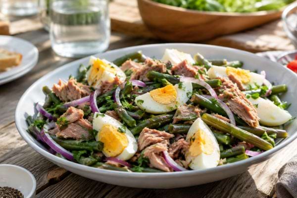 salade de haricots verts avec thon et oeuf dans une assiette blanche