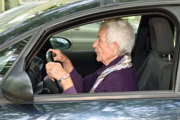 une femme âgée cheveux courts au volant d'une voiture