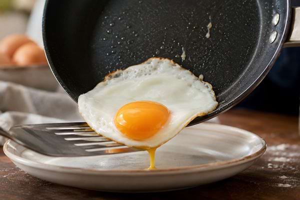 Gros plan sur un &oelig;uf au plat qui se d&eacute;tache de la po&ecirc;le sans coller.