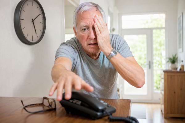 Homme couvrant un &oelig;il et saisissant le t&eacute;l&eacute;phone apr&egrave;s une perte soudaine de vision.