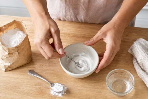 Préparation d’une pâte au bicarbonate et à l’eau dans un petit bol.