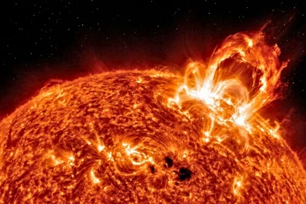 a massive, glowing solar flare erupting from the surface of the sun