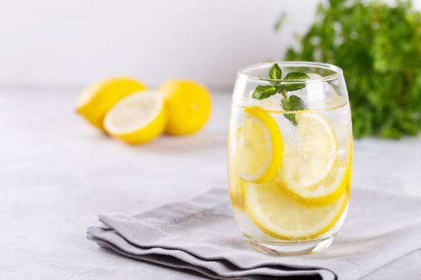 un verre d'eau posé sur une serviette avec du citron