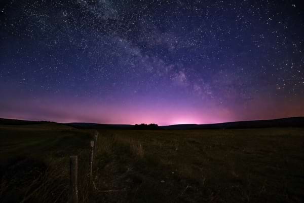 a dark field in the countryside at night, no city lights