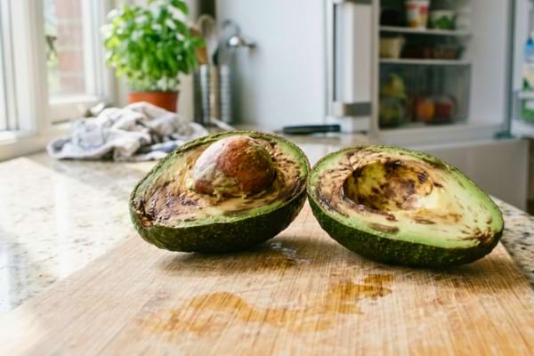 un avocat coupé en deux, dont la chair est à moitié brunie et abîmée