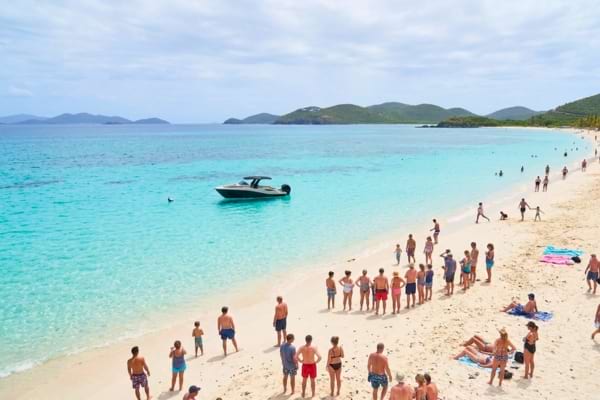 a small white speedboat stranded in shallow turquoise waters near a sandy beach