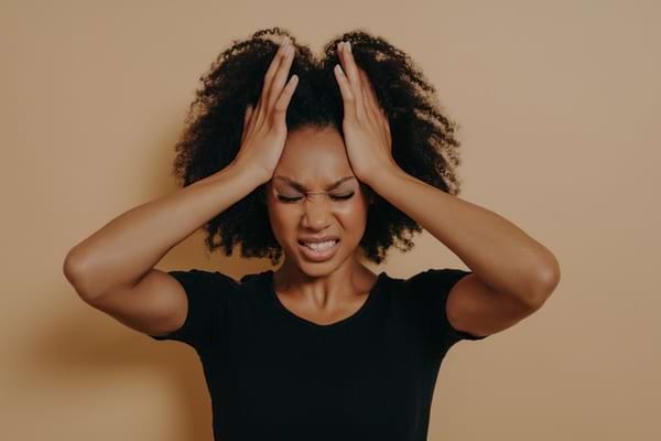 Femme stressée se tenant la tête avec les deux mains