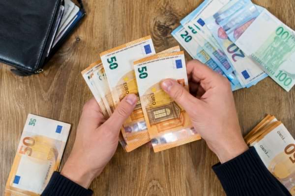 mains en train de compter minutieusement des billets de banque