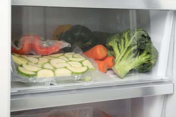 Légumes et rondelles de courgettes emballés sous vide dans un réfrigérateur.