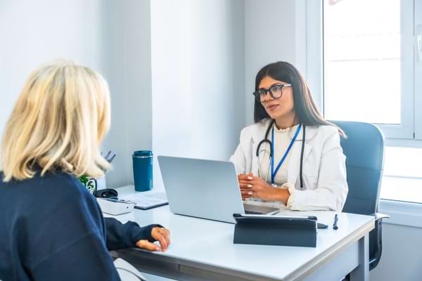 Médecin échangeant avec une patiente au cours d’une consultation.