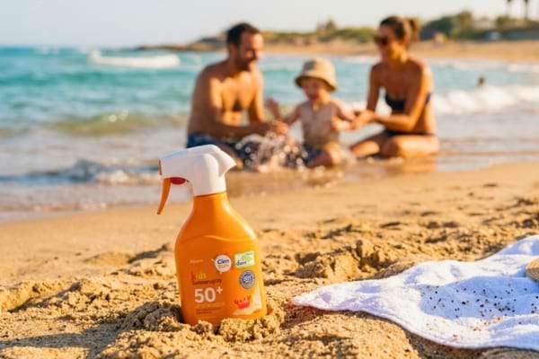 Un flacon de crème solaire planté dans le sable