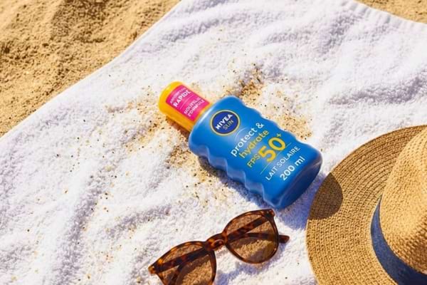 un tube de Crème solaire nivea sur une serviette de bain