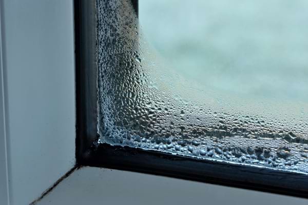 gouttes d'eau perlant sur une vitre de fenêtre en hiver
