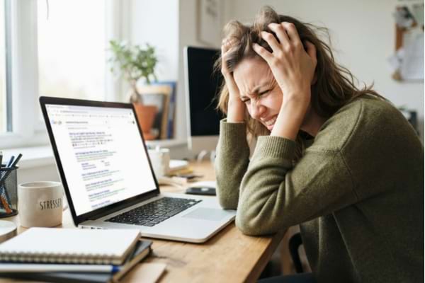 une personne agacée devant son écran d'ordinateur portable,