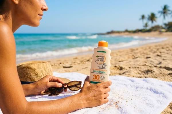 une femme tenant de la crème solaire