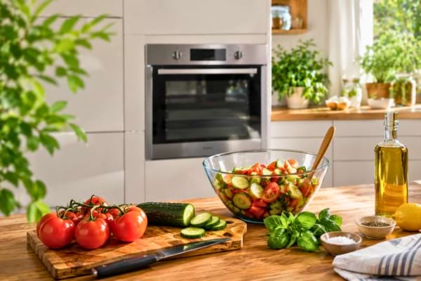 a fresh, colorful summer salad is being prepared with tomatoes and cucumbers