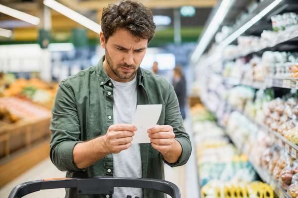 une personne regardant un ticket de caisse avec une expression concentrée